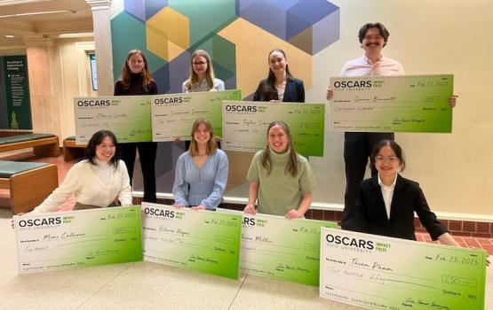  The finalists in the OSCARS Impact Competition pose  with giant checks showing their awards 