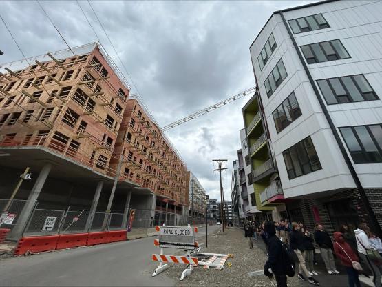  Two buildings with a street between them against a cloudy sky. 
