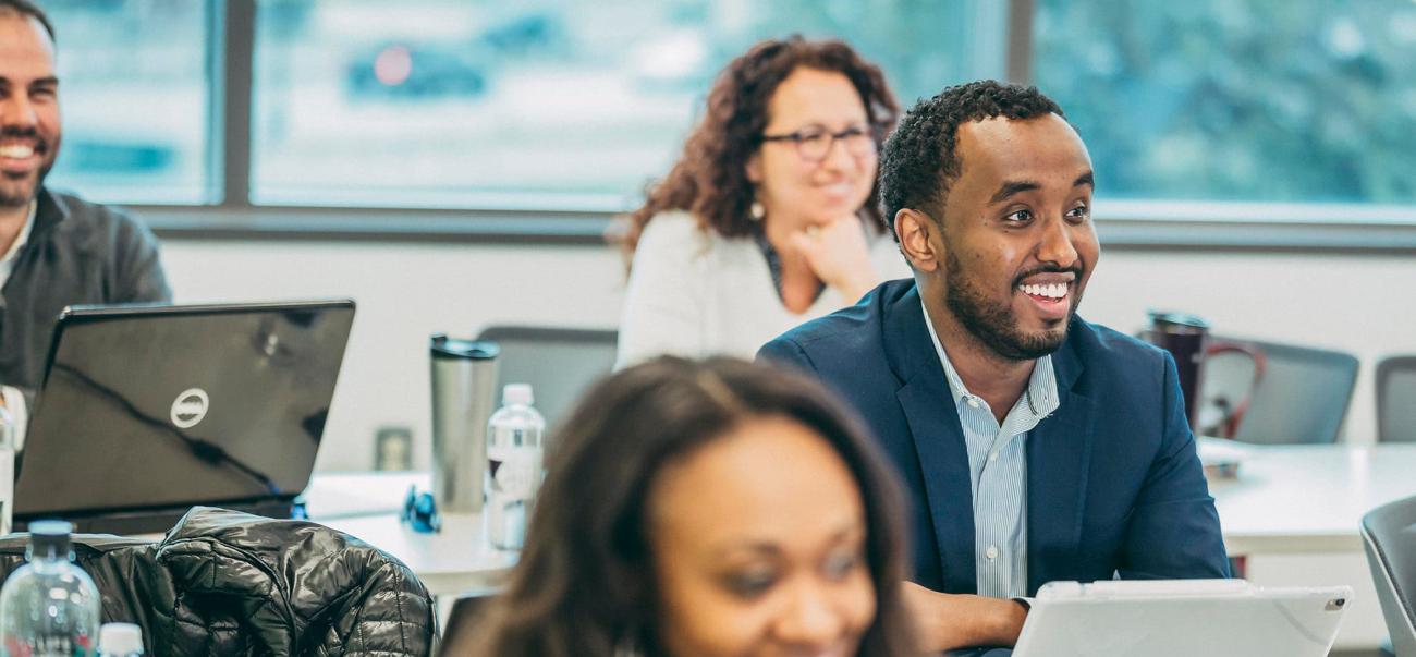 Graduate students smile during class