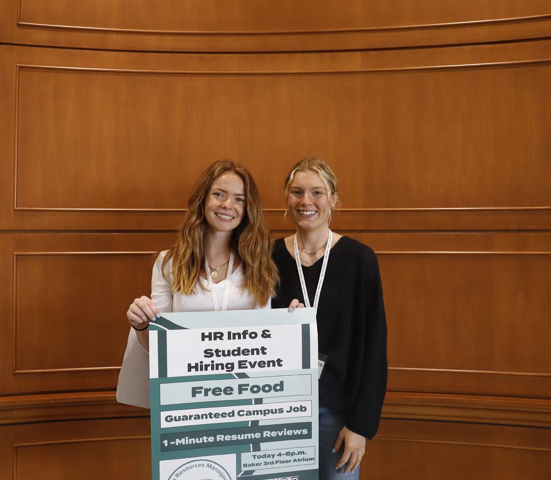 Two students holding HR sign