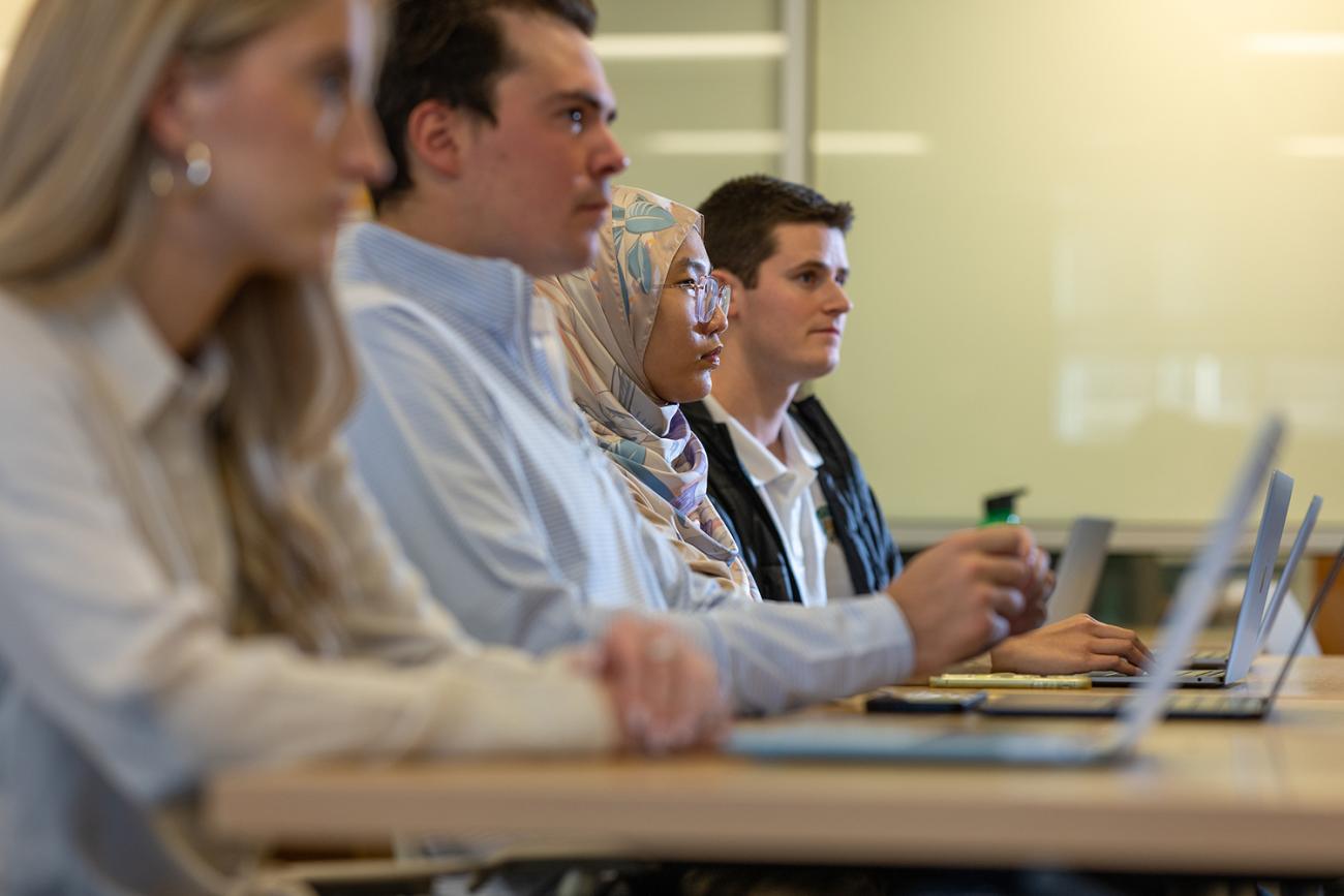 MBA students work together on their laptops