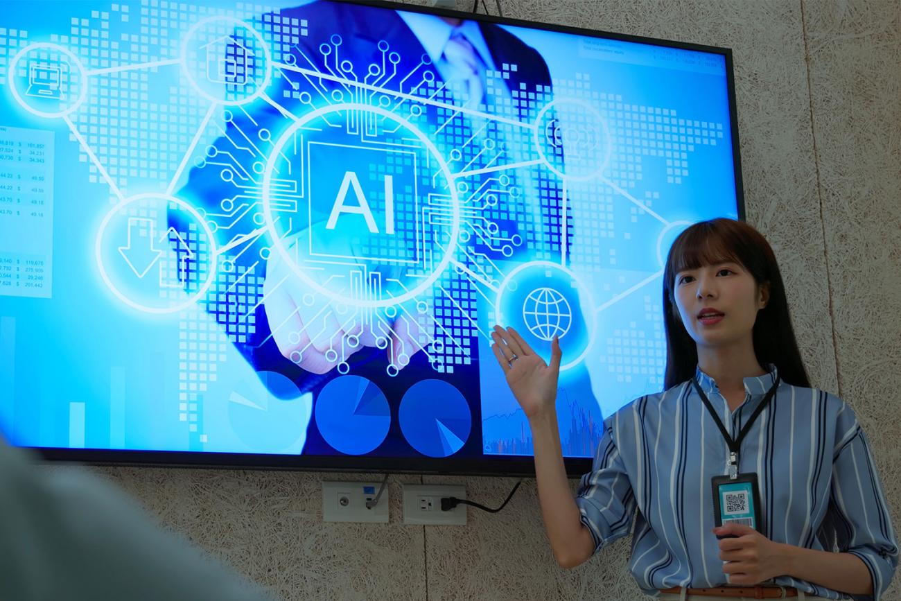 AI certificate teacher standing by monitor with AI graphics