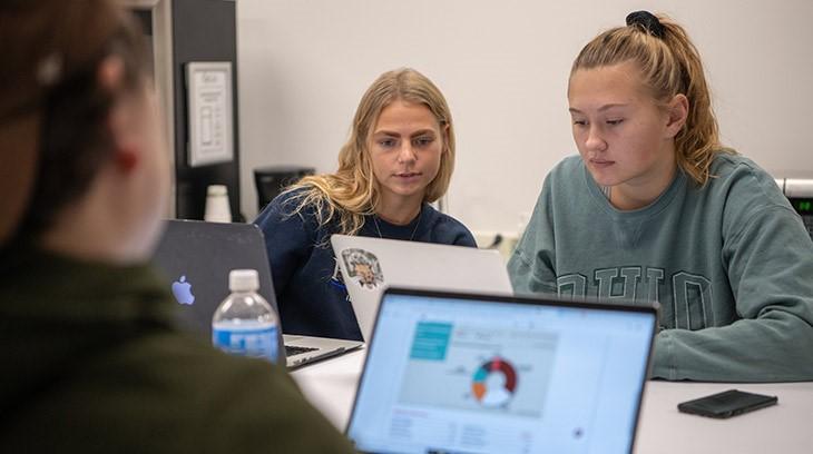Students work together on laptops during class