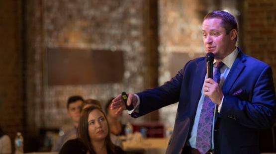 College of Business alumni speaks into a microphone