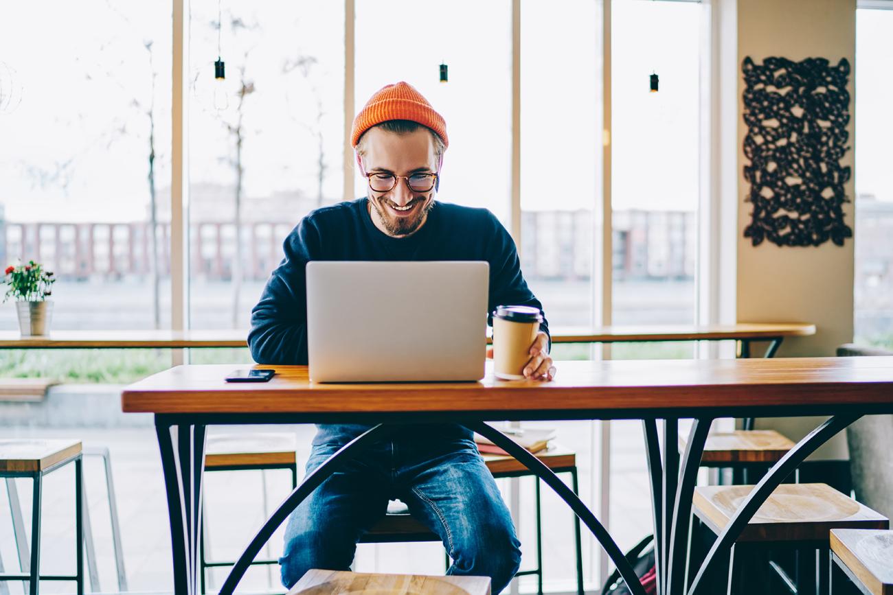 Man sits at laptop in a coffee shop