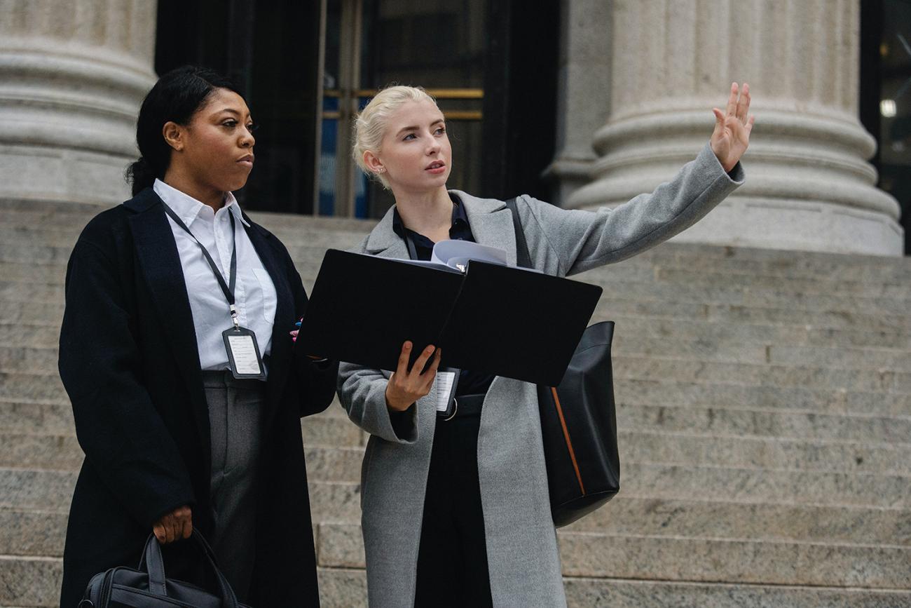 Two women standing in front of a building