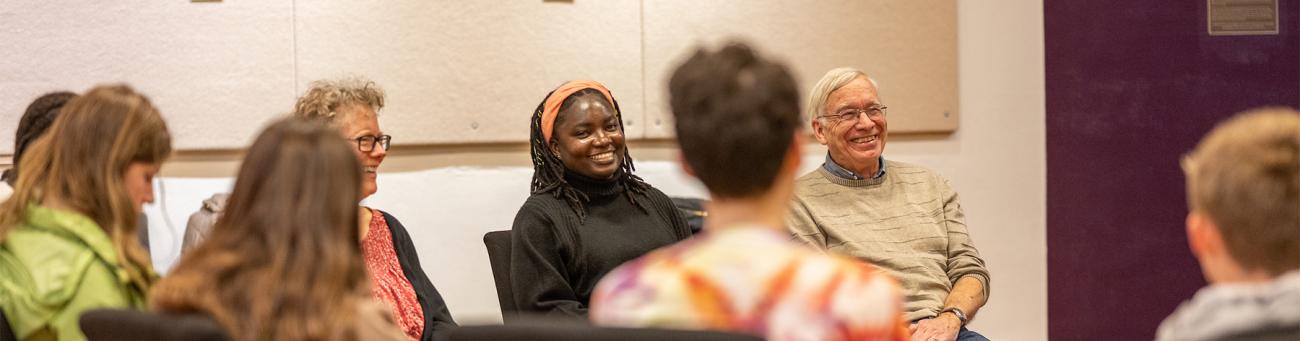 Individuals sit in a circle and have a discussion during a workshop