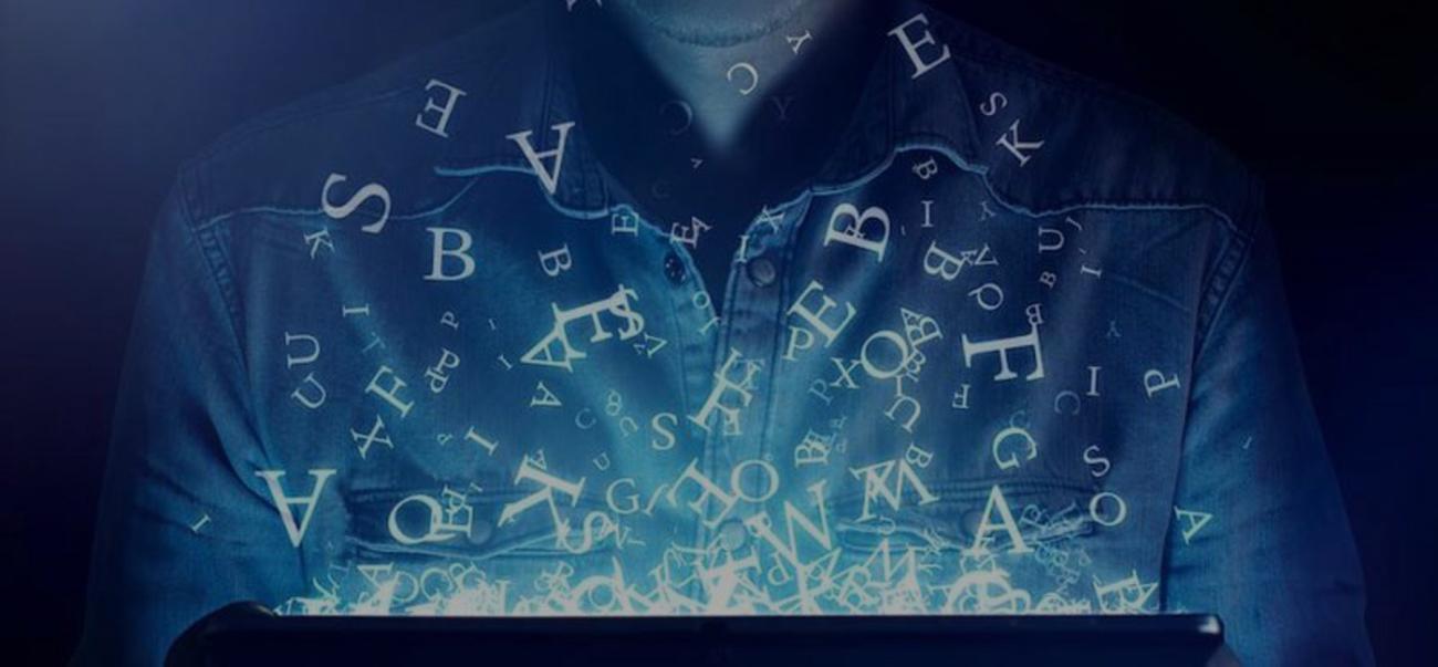 This photo illustrates language and technology, with letters flyout out of a computer onto a human being.