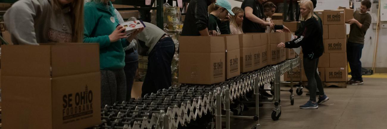 Ohio University students pack boxes at the SE Ohio Food Bank.