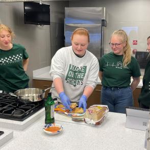 Culinary Students in a kitchen creating a sandwich