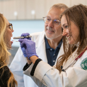 Physician Assistant checking a patient with an instructor overseeing the student