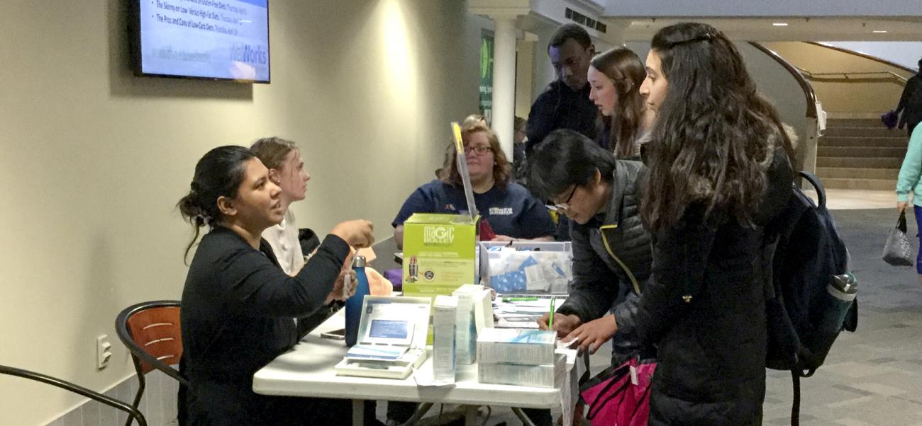 Students picking up their stuff from professors