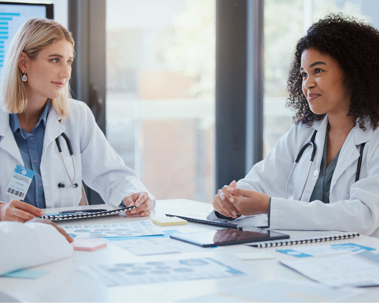 Two doctors smile and strategize healthcare decisions.