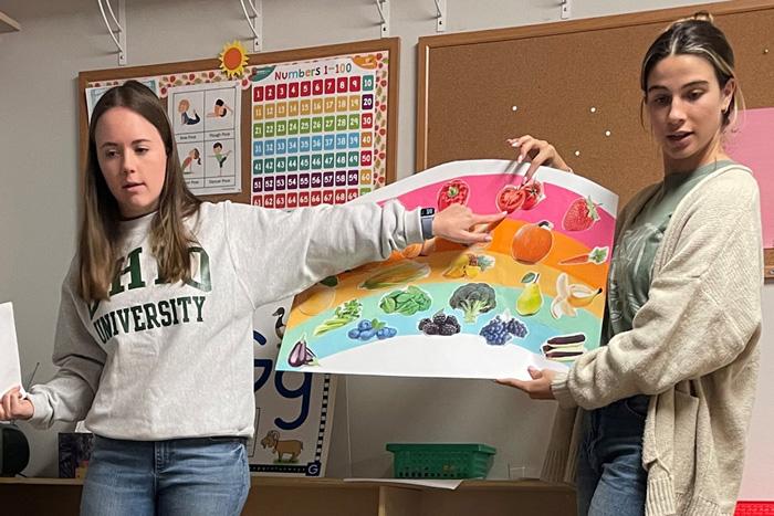 Ohio University students in the nutrition program discuss food groups with schoolchildren.