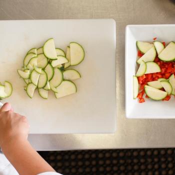 Student in nutrition class chopping vegetables
