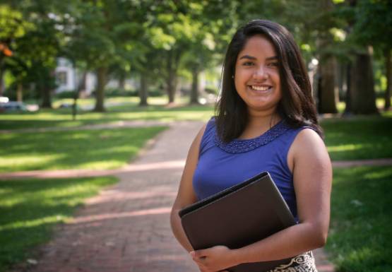 student standing on the college green eager to start classes