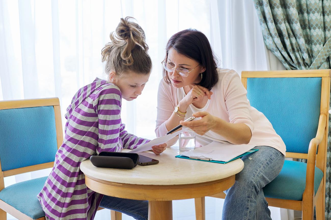Adult counselor talking to a young teenage girl 