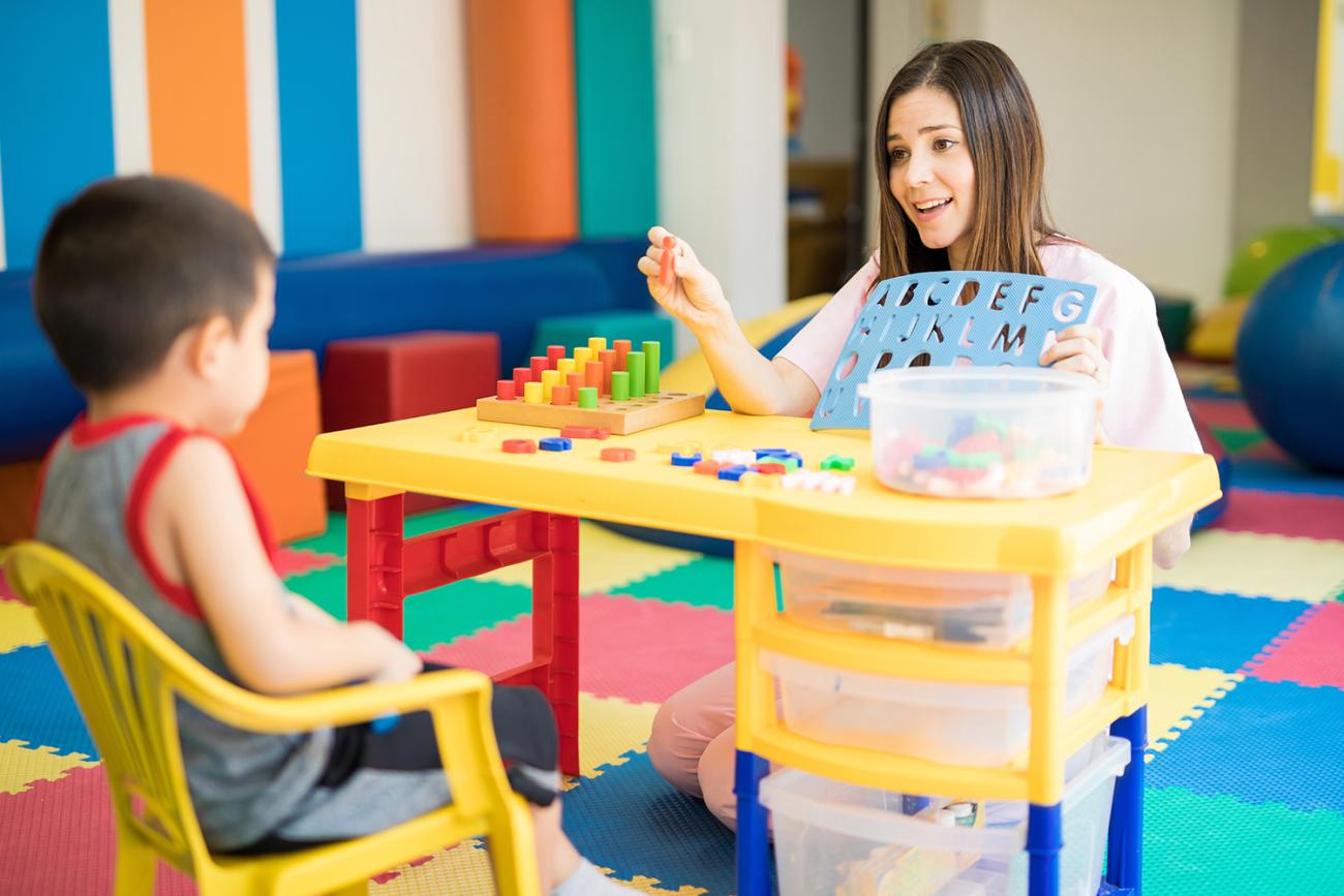 teacher holding up alphabet teaching tool