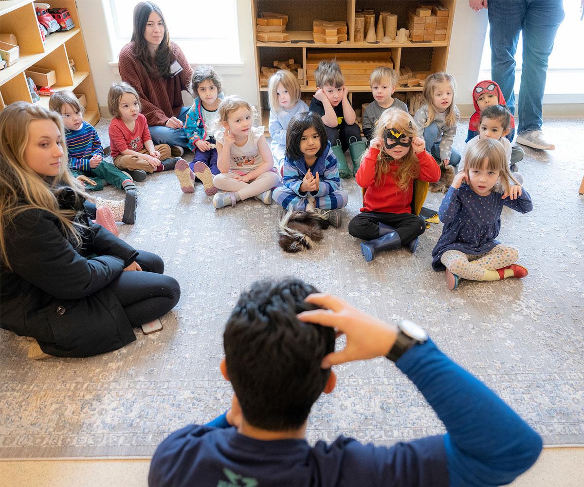 A teacher works with a group of children during class.