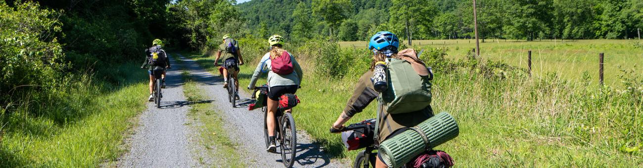 Students ride bikes on a trail.
