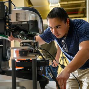 Engineering student working on a machine.