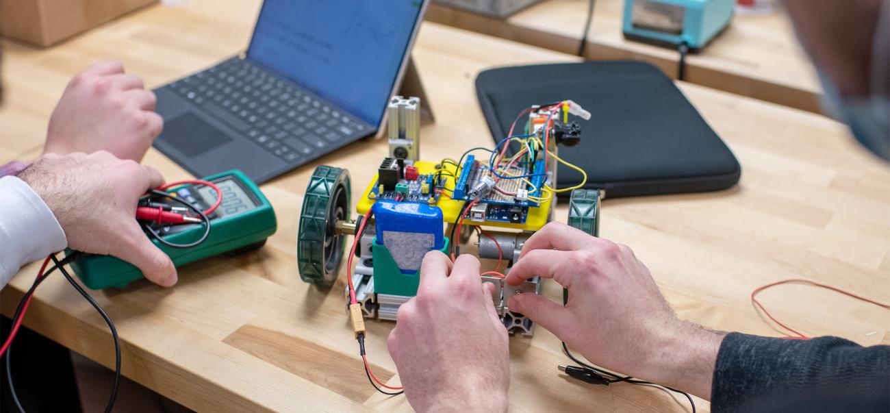 Students work on a robot together.