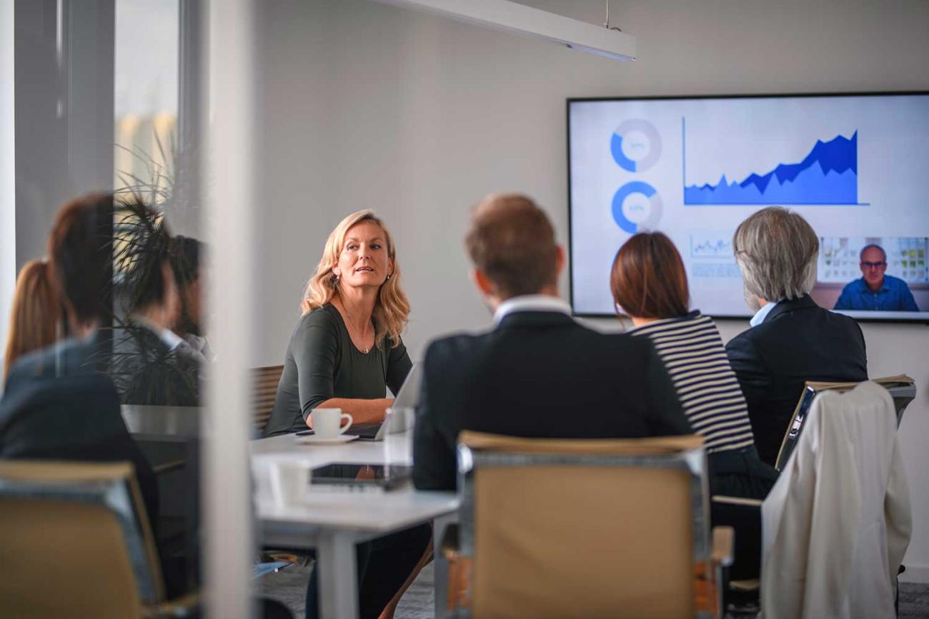 Woman sitting at table with colleagues discussing engineering management certificate