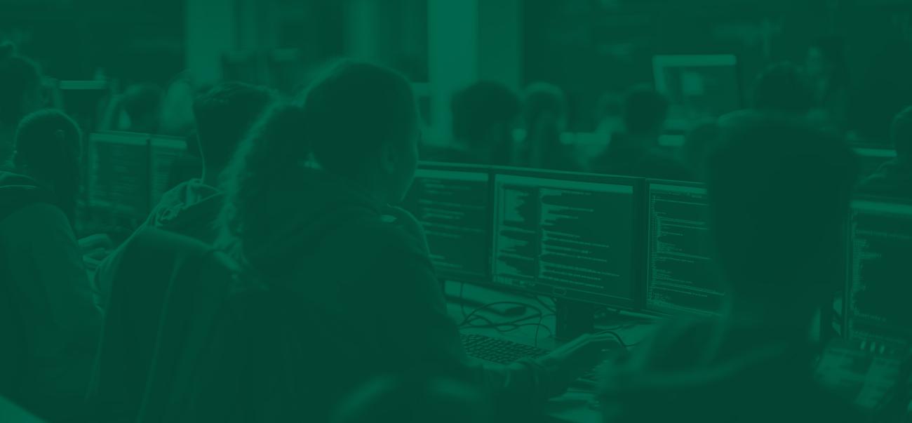 Students work at computers in a computer science college class