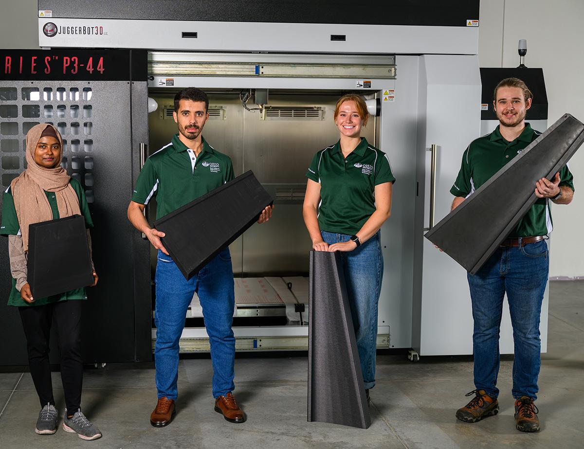 Four students hold sustainable materials created in the ISEE labs.