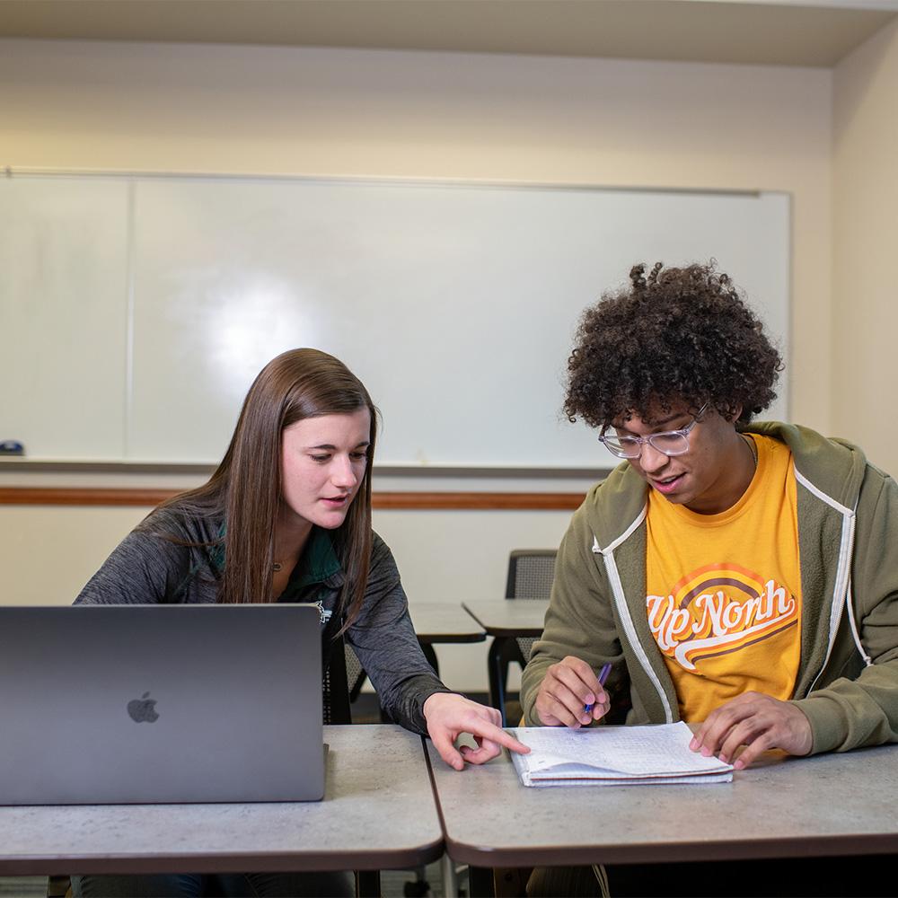 A student helps another student with homework.