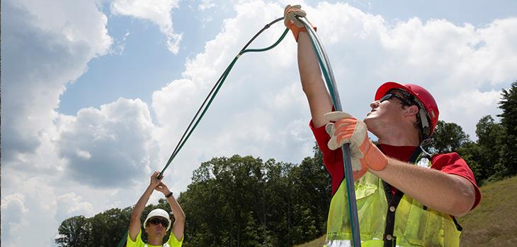 Men wearing hard hats, vests, and work gloves
