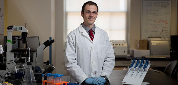 A person standing within a biomedical research lab.