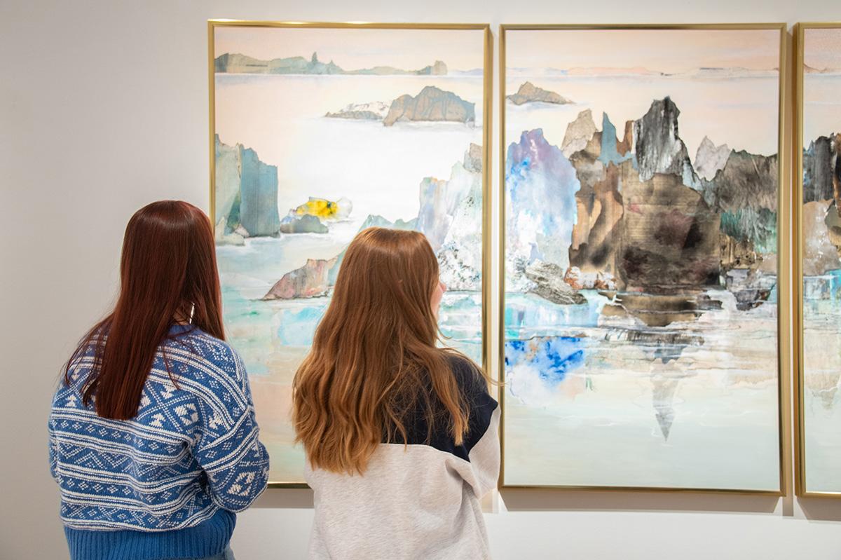 two women looking at art in a gallery