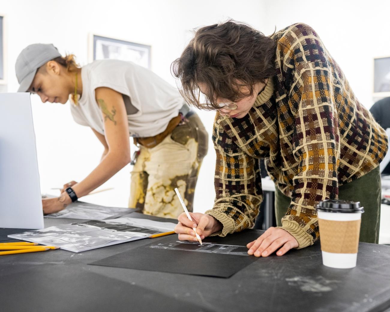 two people drawing in a drawing class