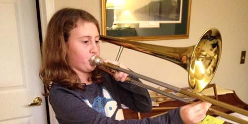 A student plays a trombone