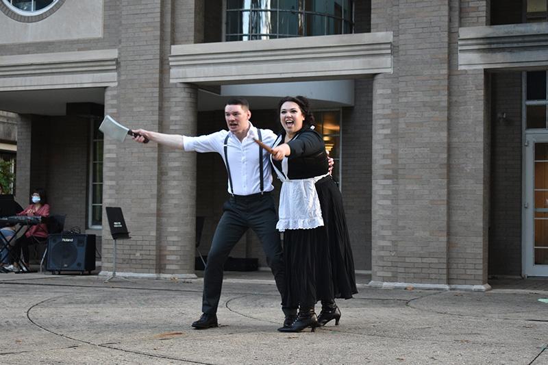 Two performers in front of facade 