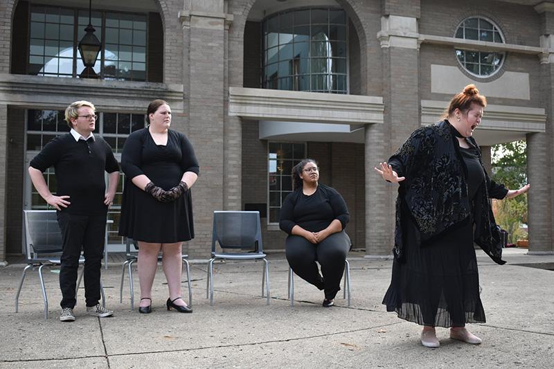 Four performers in front of facade