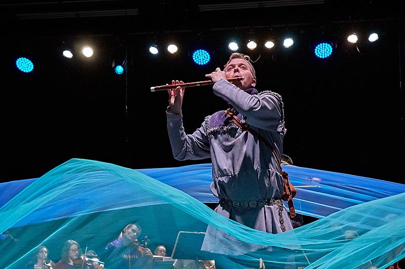 Person playing flute, flowing fabric
