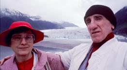 Portrait-style photo of a man and a woman with a beach in the background