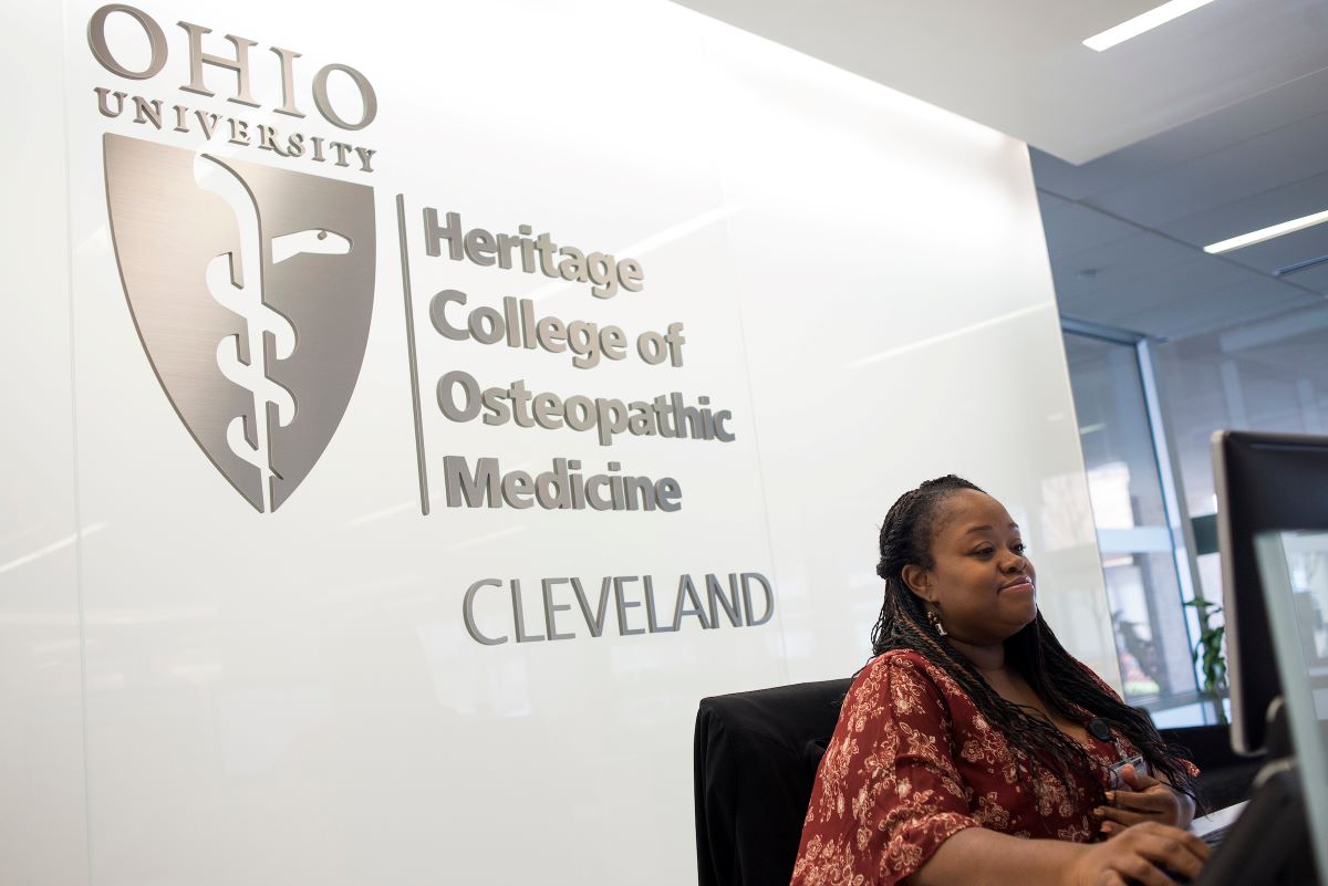 A person sits at a desk, using a computer at Heritage College's Cleveland campus