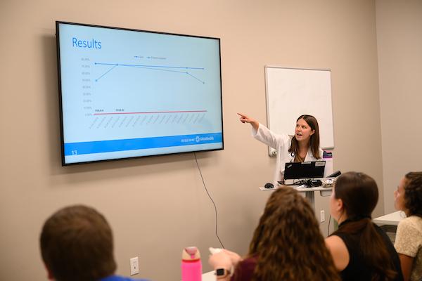 Female medical student giving a presentation to a group of people