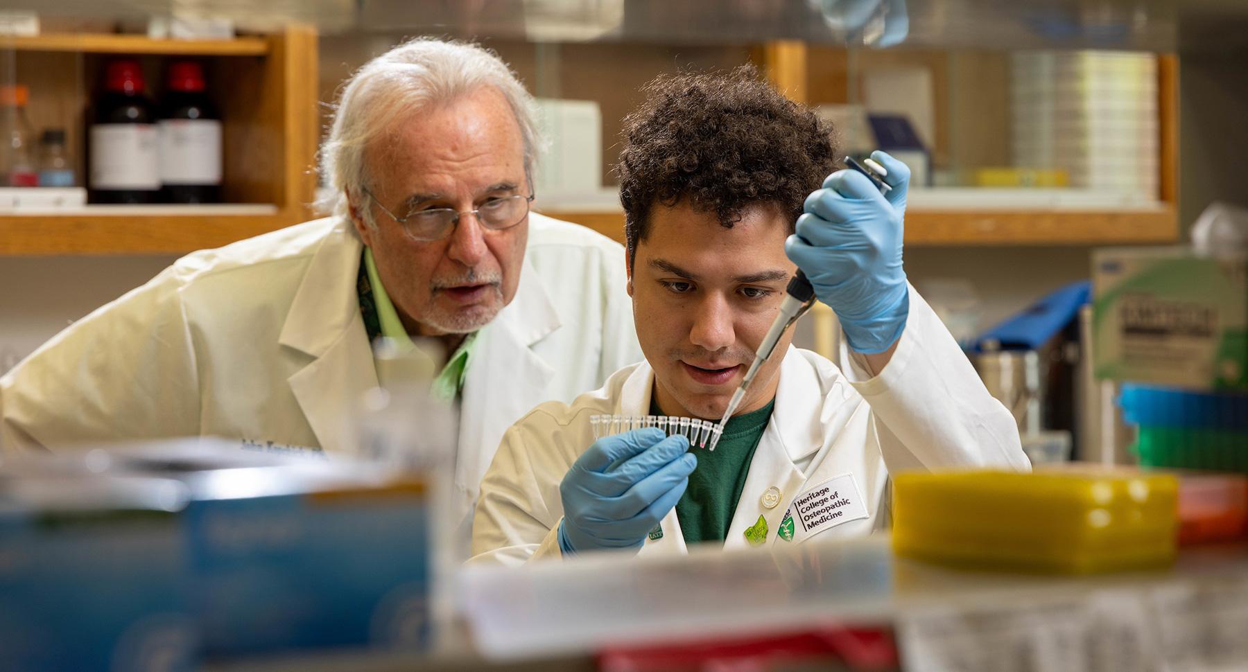 John Kopchick observing student in a lab.