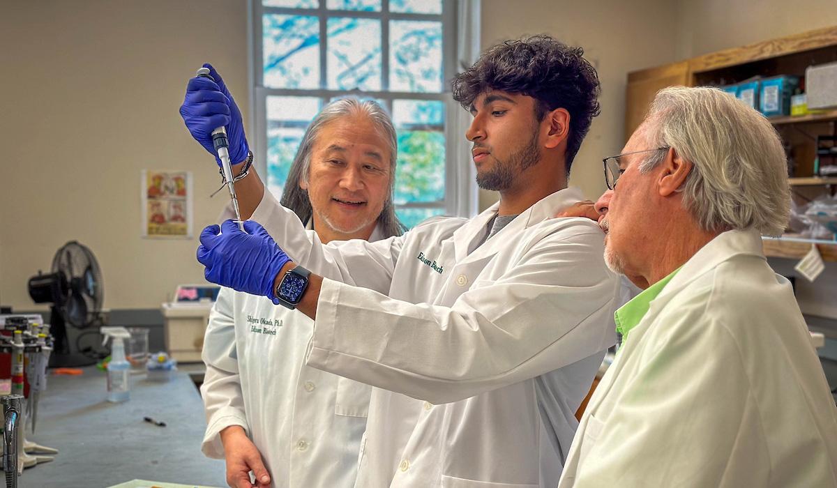 Student being mentored by scientists.