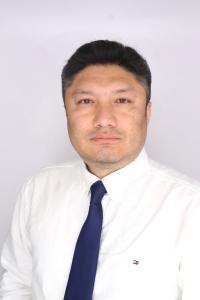 Adil Supiyev headshot, white shirt and blue tie