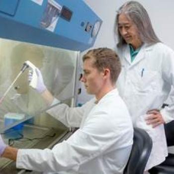 A Heritage College student and faculty member work together in a lab.
