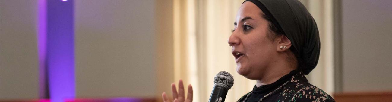 A woman speaks into a microphone
