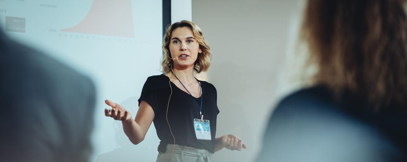 Woman gives a presentation in front of a projector