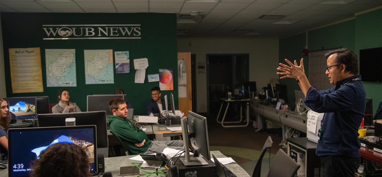 A professor addresses students in a journalism class.