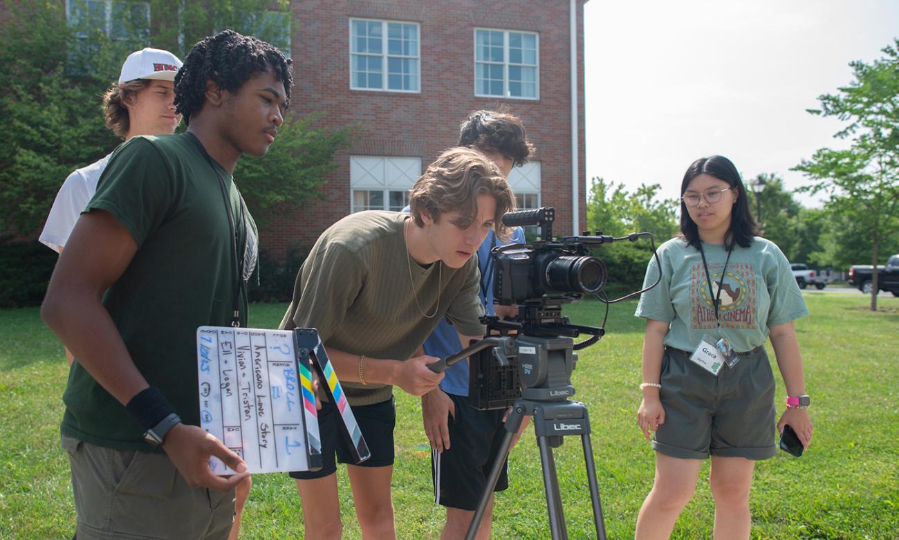 high school students using a camera for a workshop