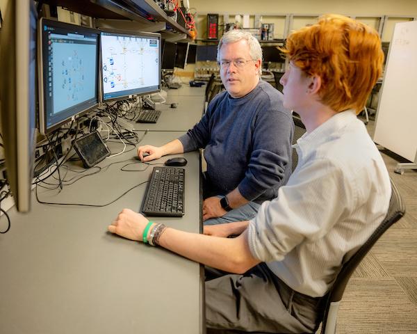 Faculty and student discussing a network configuration in the Schoonover labs